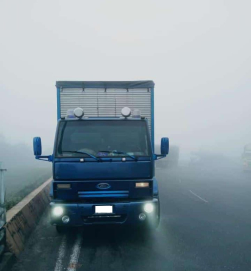 Vehículo transitando por vía en tiempo nublado